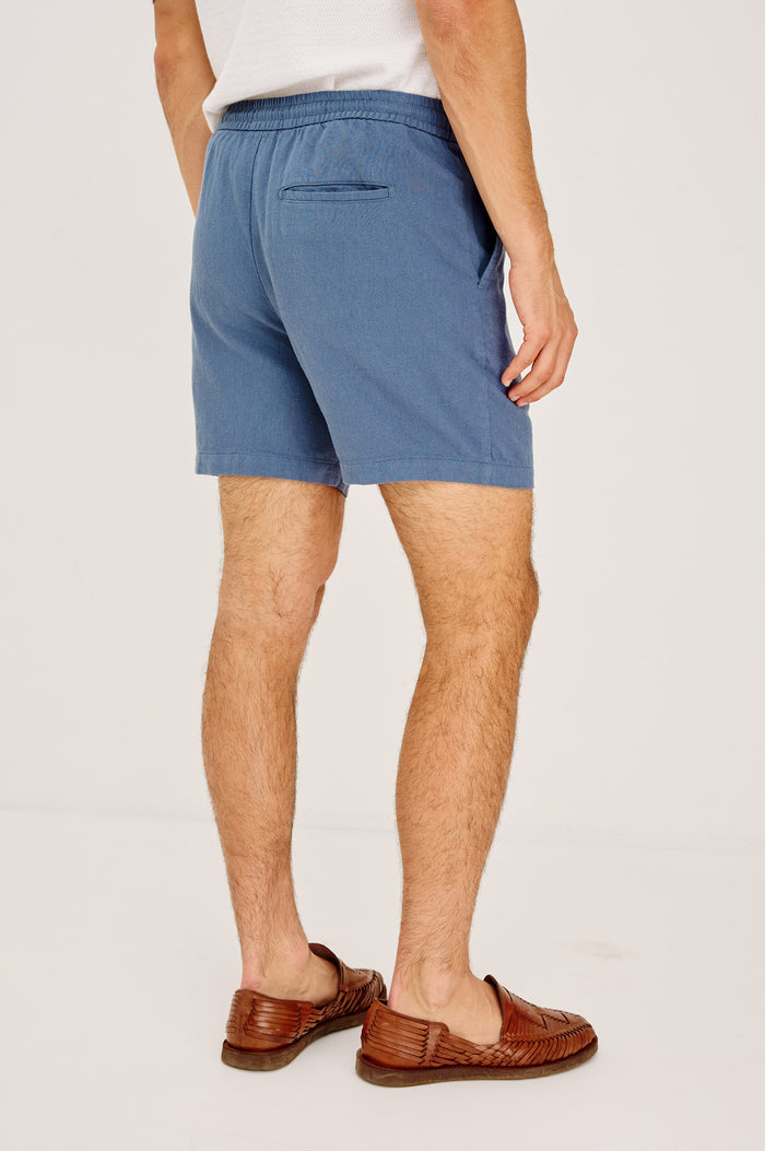 Archer Short in Cotton-Linen Blend With Relaxed Fit, Elastic Drawstring Waist, Front Zip Fly, Side Pockets, and Back Welt Pocket in Washed Blue Colorway - Back View Featured on Model
