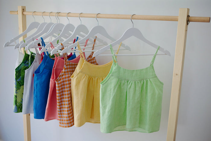 Hanging cami tops in various colours on a rack.
