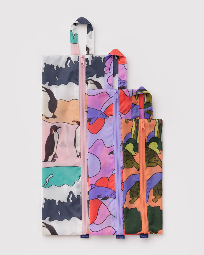 Set of three colourful bags with animal patterns lying flat.