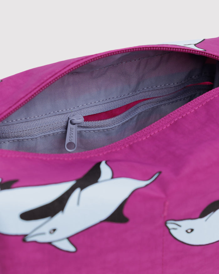 Pink bag with dolphin design and top zipper open showing purple lining and zip pocket.