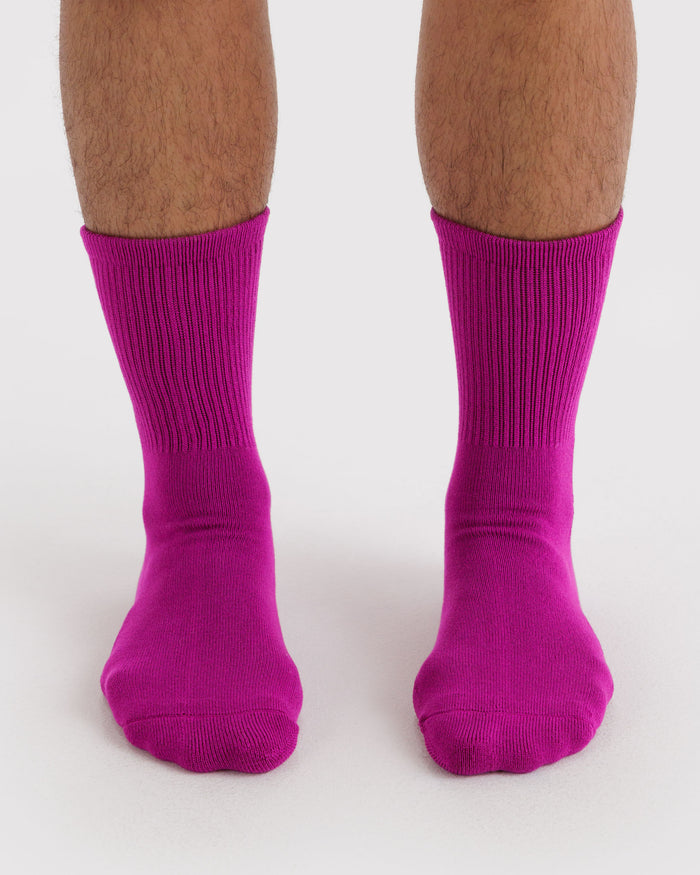 Vibrant pink ribbed socks worn by a person.