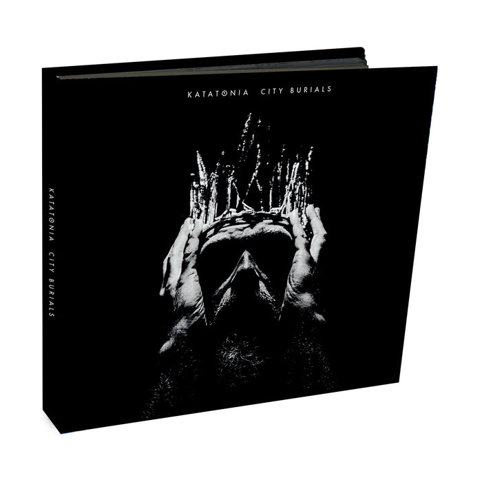 Katatonias City Burials album cover shows a black and white image of a person holding their head, layered with abstract patterns. The design captures the moody essence of progressive rock on a black background with white text.