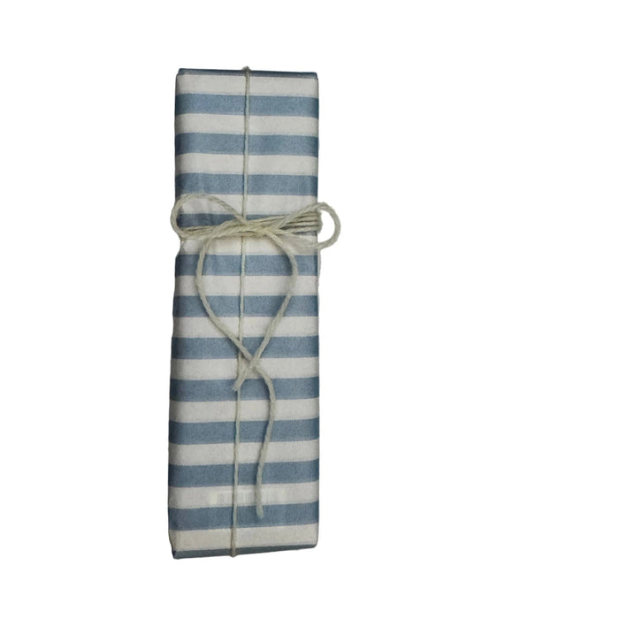 Rectangular box wrapped in blue and white striped paper and tied with cream wool.