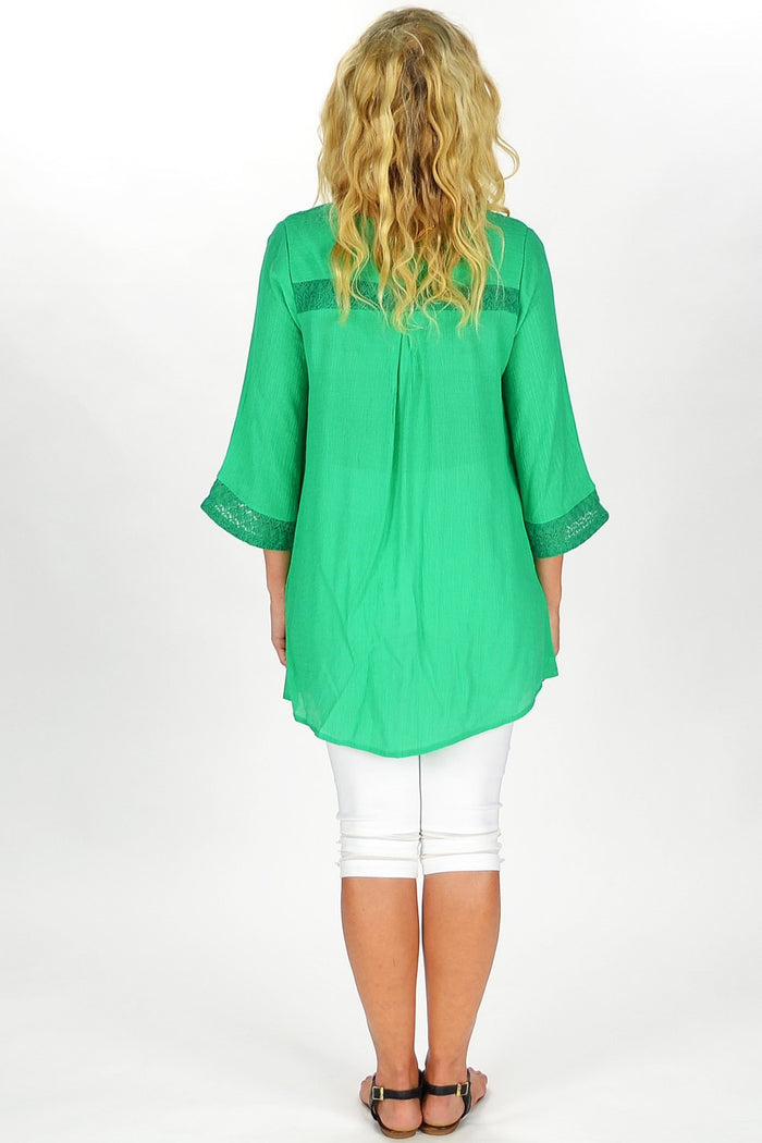 Green Goddess Tunic by David Jessie, flowing green fabric with intricate embroidery, displayed on a hanger.