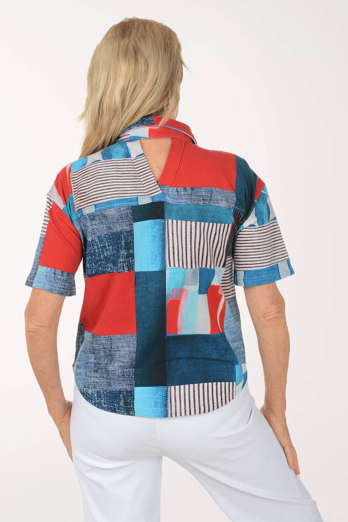 Woman wearing a colorful patchwork blouse with a white background