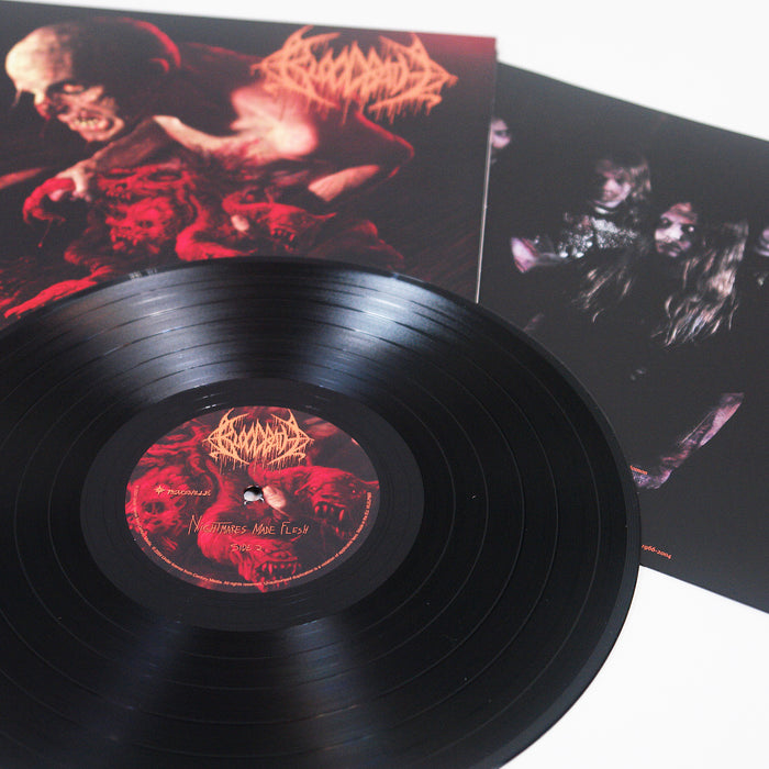 A black Bloodbath vinyl record with red and orange gory artwork, plus a printed inner sleeve featuring band members with long hair and dark clothing.