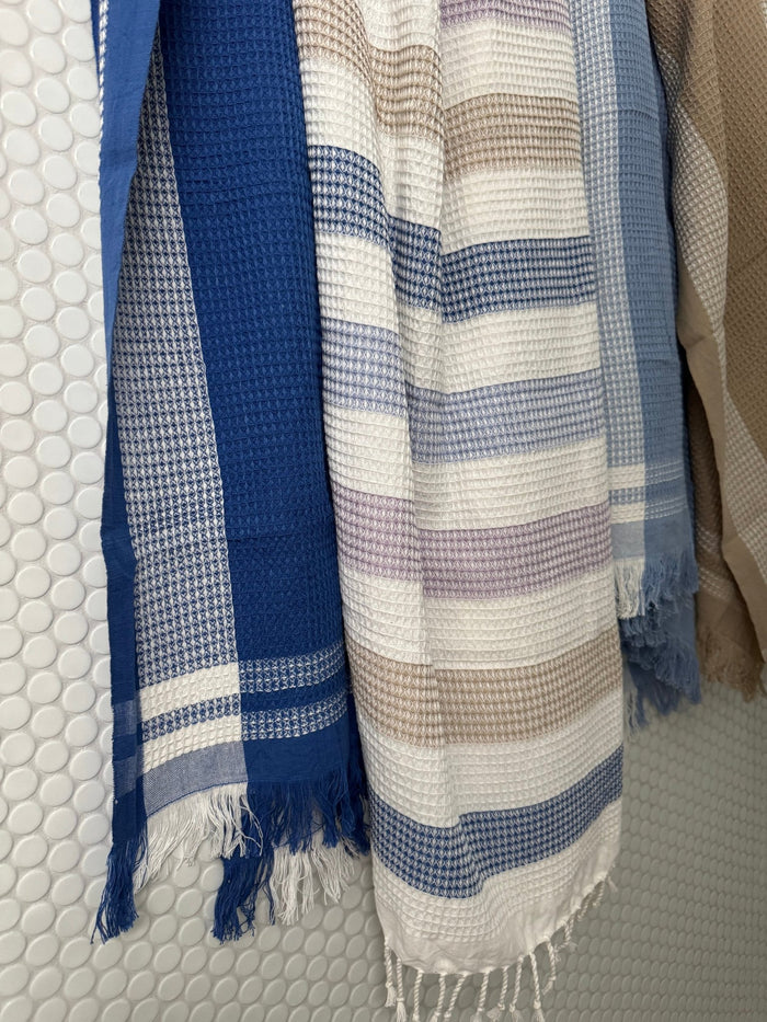 All colours of handwoven Waffle Towels hanging over tiled wall - ANNIE.G