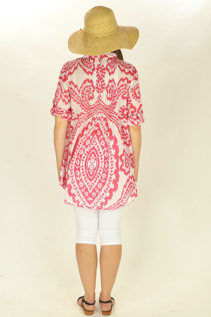 Red Rosa tunic by sunnsand, featuring flowing fabric and relaxed fit, displayed on a hanger against a neutral background.