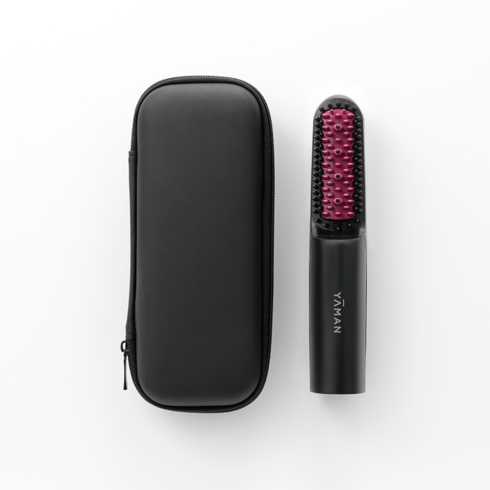 Black hairbrush with red bristles and carrying case on a white background