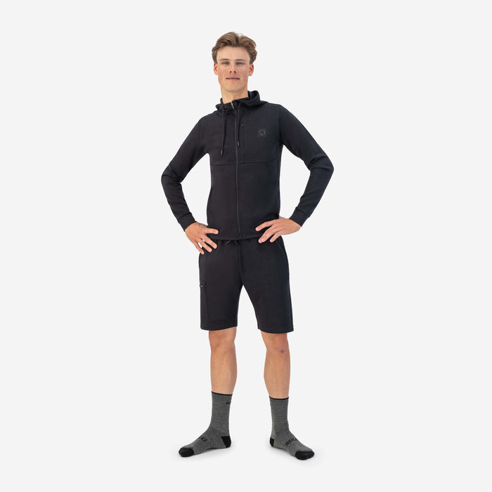 Rogelli korte trainingsbroek heren zwart gedragen totaalshot met zwart trainingsvest.
