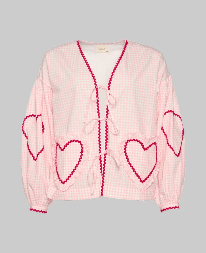 women's pink checked long sleeve blouse with heart shaped pockets and front tie closure with red ric rac detail.