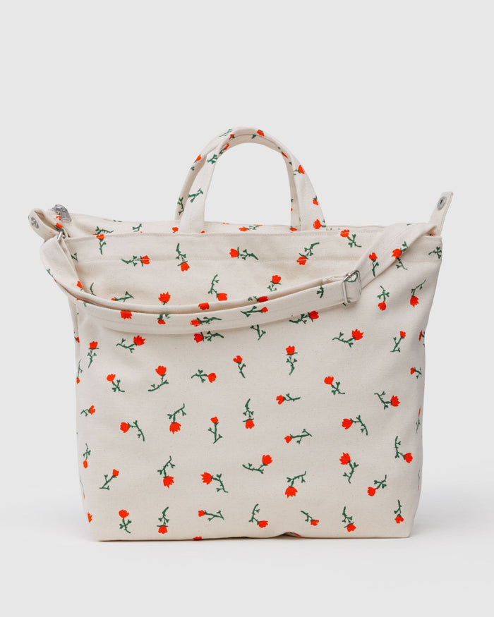 White with red wildflower patterned tote bag with carry handles, adjustable strap with silver hardware and zip top closure