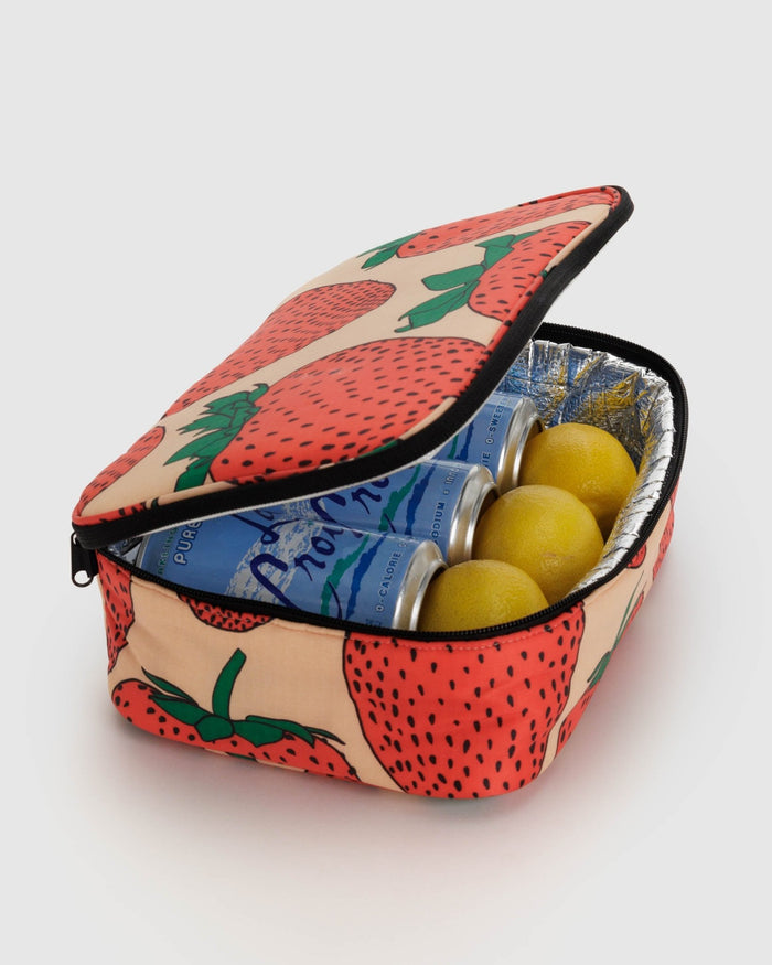 Light pink and strawberry patterned insulated lunch box with zip open and drink cans and lemons inside.