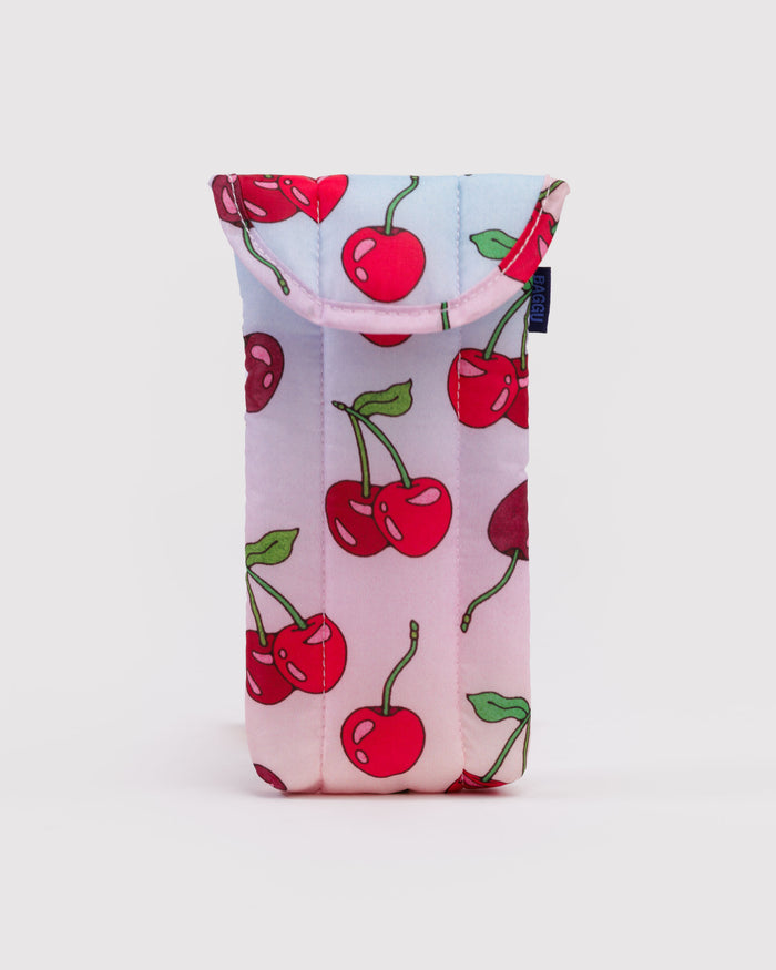 Quilted and puffy eyeglasses sleeve with cherry pattern on a light pink and blue background.