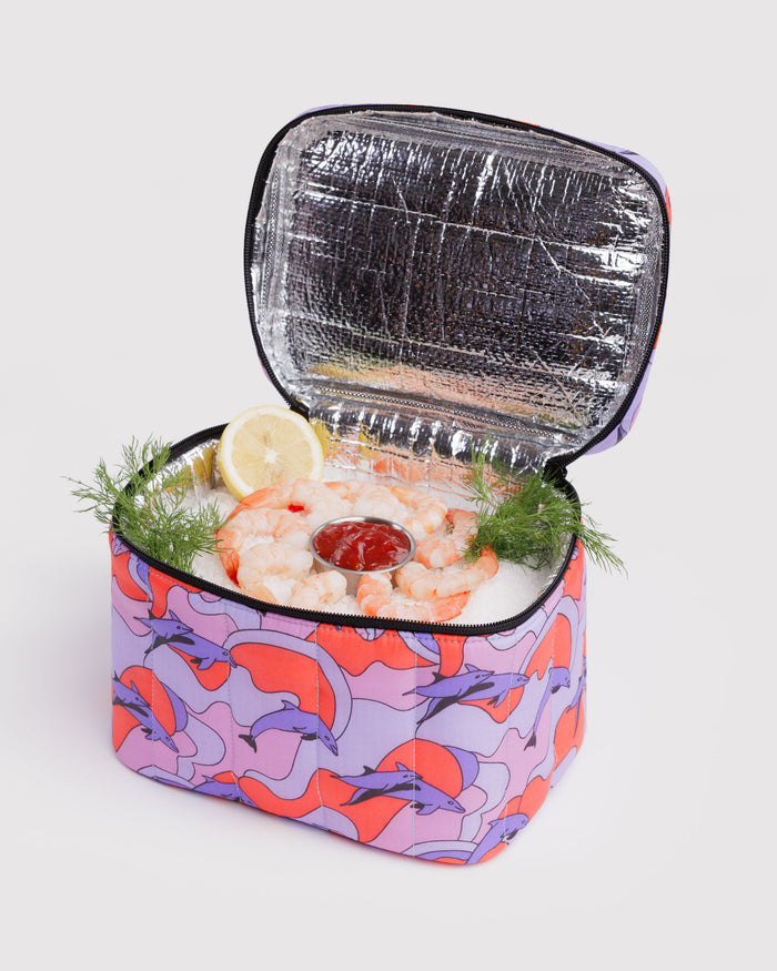 Dolphin print insulated cooler with shrimp and lemon inside showing silver lining insulation and black zip closure.