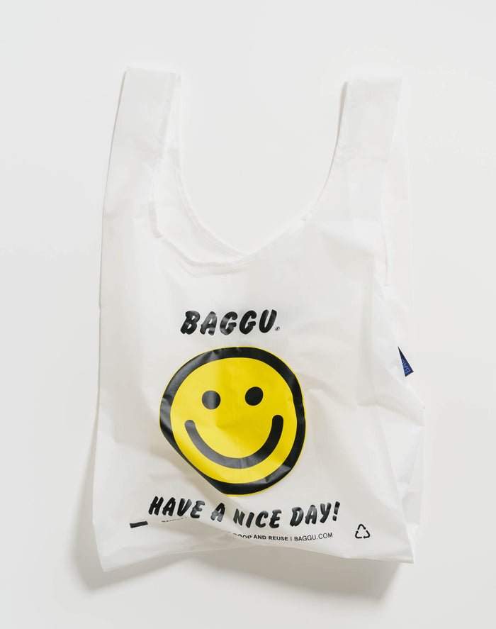 White reusable bag with a yellow smiley face and text.
