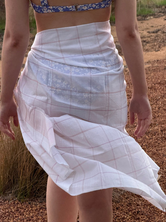 Woman wearing a pink checked sarong over bathers - ANNIE.G