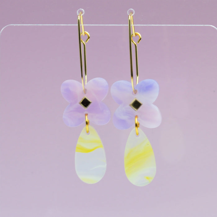 Drop earring in acrylic clover flower in lavender swirl colour with mirror diamond centre and tear drop attached in yellow and white swirl colours.