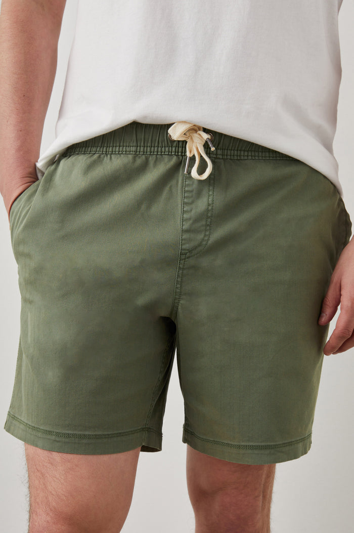 Cruz Short in Vintage-Washed Cotton With Drawstring Ties, Side Pockets, and Back Button Patch Pockets in Spring Olive Colorway - Lower Body Front View Featured on Model