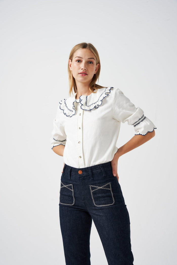 Close up of front buttons and collar on a white shirt worn by a woman in blue jeans - ANNIE.G