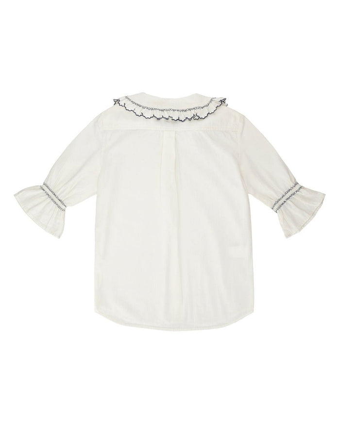 Back of a white blouse with a collar and puff sleeves with navy blue decorative stitching.