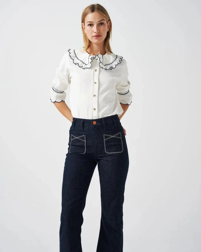 Person wearing a white three quarter sleeve shirt with collar and blue embroidery trim with blue jeans - ANNIE.G