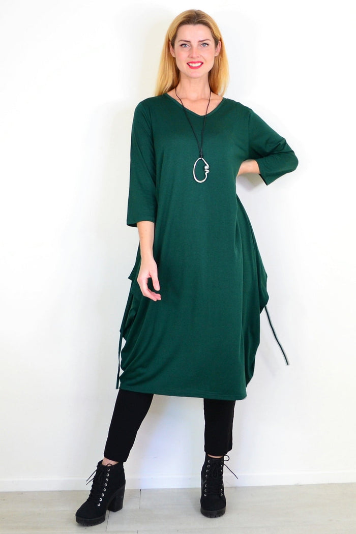Dark green Lilia Whispers oversized tunic dress displayed on a hanger, showcasing its relaxed fit and flowing fabric.