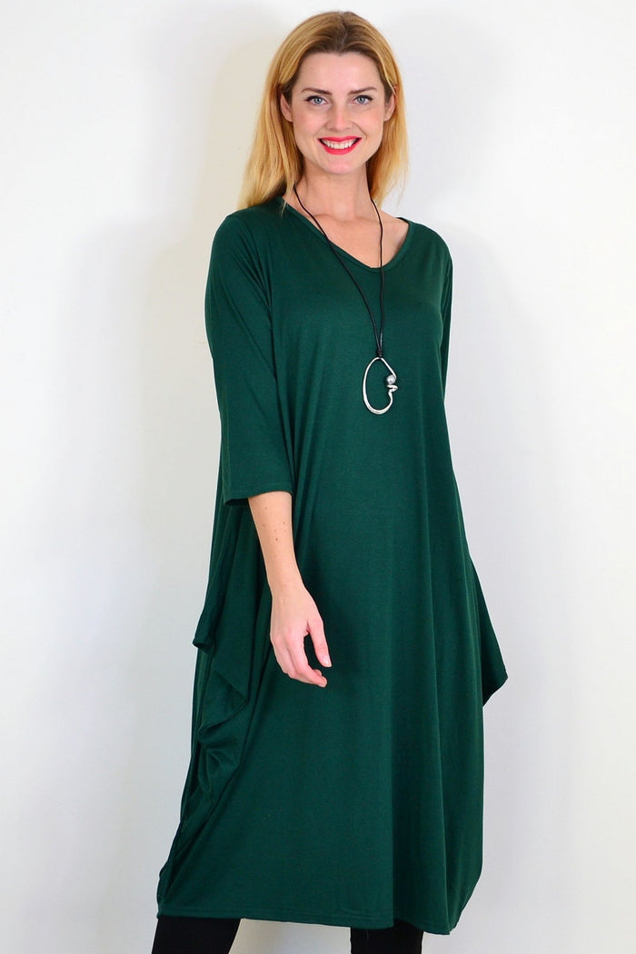 Dark green oversized tunic dress by Lilia Whispers, relaxed fit with long sleeves and flowing silhouette, hanging on a hanger.