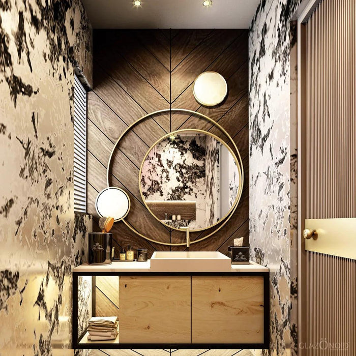 Stylish bathroom mirror with a metal frame, the metal frame is made of 2 round rings. Mounted over a wooden countertop with a white sink and some boxes of make up kept over it.