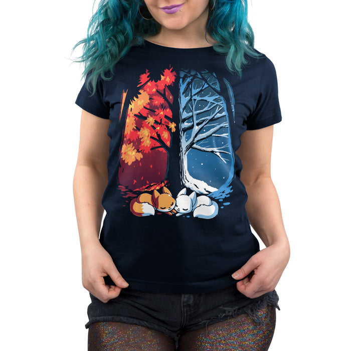 Premium Cotton T-shirt_TeeTurtle navy blue Fall & Winter Foxes apparel featuring an orange fox on the lefthand side, and a white fox on the righthand side with their cheeks touching in the middle, and a fall forest background on the left, and a winter forest background on the right.