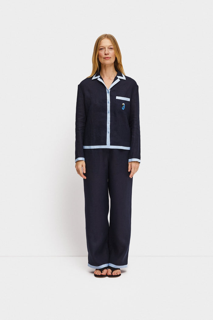 Woman wearing a matching navy long sleeve shirt and long pyjama pants sleepwear set.