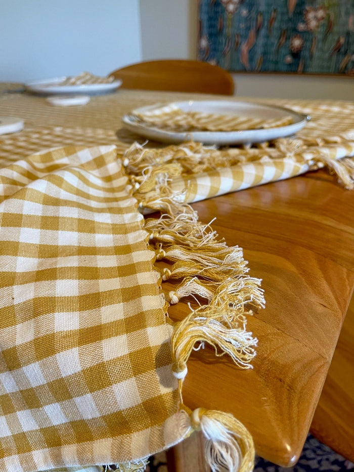 Hand knotted edge of Gold Gingham Cotton Tablecloth on a table top - ANNIE.G