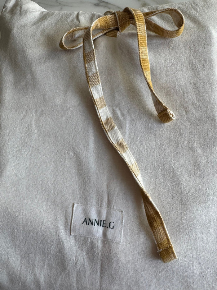 White storage bag with gold and white checked ties with ANNIE.G brand label - ANNIE.G