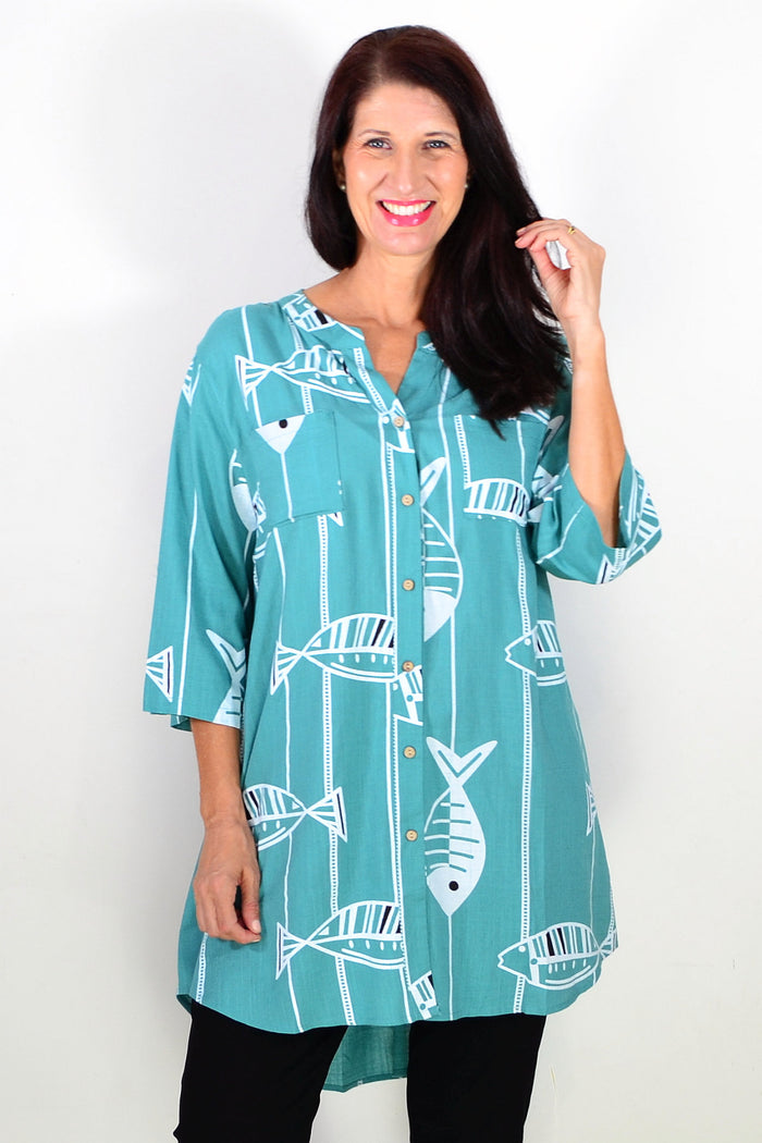 Green hi-low relaxed tunic shirt by Ruby Rain, featuring a flowy design and casual fit, displayed on a hanger.