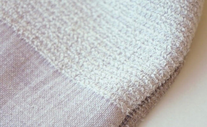 Close-up of textured towel fabric in blueberry colour.