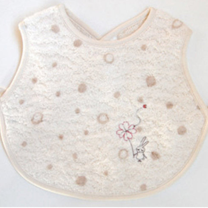 Cream baby apron bib with dots and embroidery design with back snap closure.