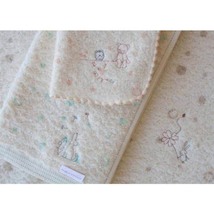 Cream baby washcloth in peach pink design on top of other designs.