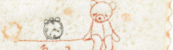 An embroidered bear and clock on a cream washcloth with peach pink dots.