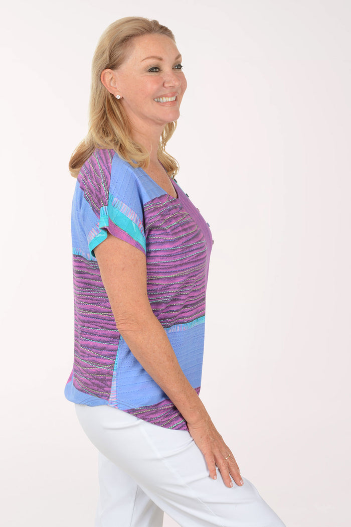 Woman wearing a colorful patterned top on a white background