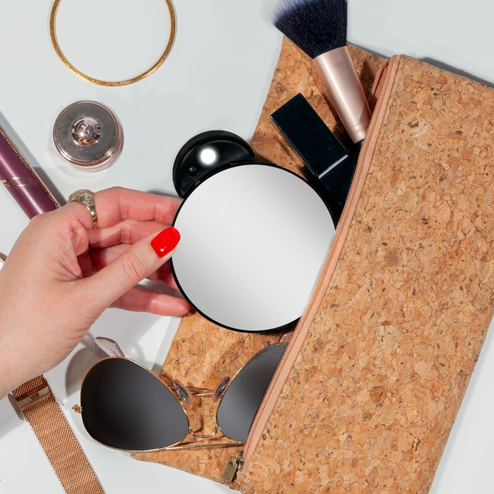 Zadro FC10LBLK 705004423960 environment photo user pulling mirror from makeup bag, lighted compact mirror with magnification & retractable suction cups in front of a real life setting