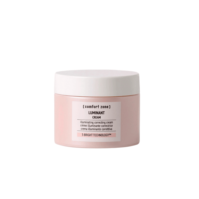 A jar of Luminant Cream | [ comfort zone ] in soft pink packaging with a white lid, designed for skincare and illuminating correction.