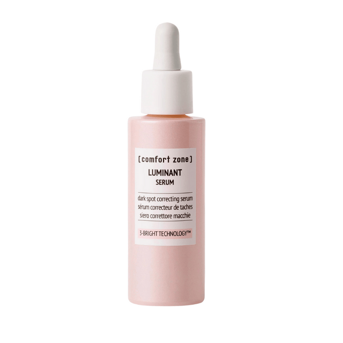 A pink dropper bottle of Luminant Serum | [ comfort zone ], a skincare product designed for dark spot correction using 3-Bright Technology.