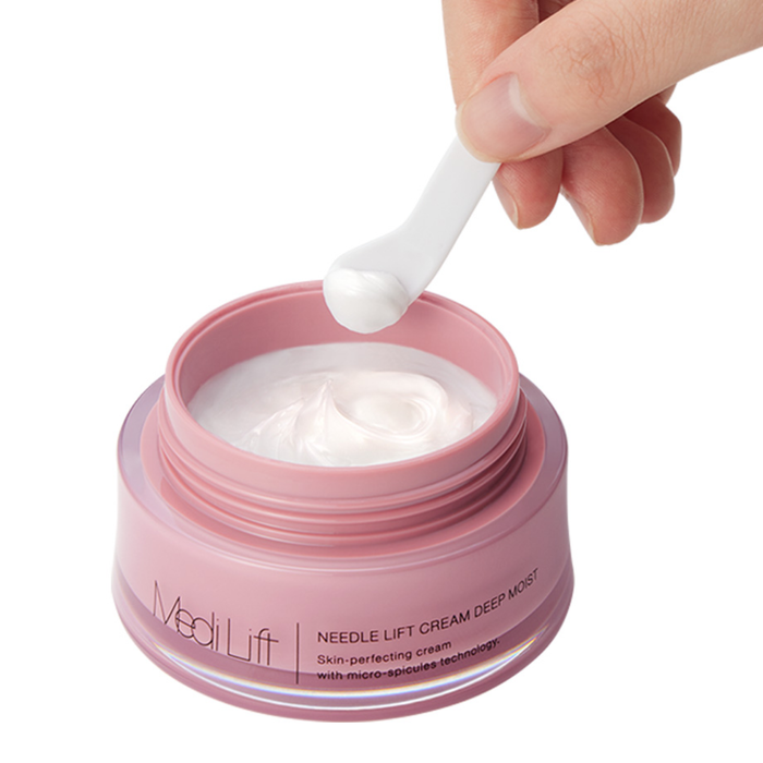Pink jar of Medi Lift cream with a hand holding a white spoon