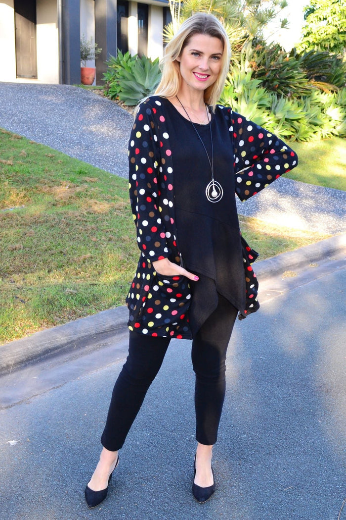 Multicolour pockets and dotted pattern Peony winter tunic top with long sleeves and round neckline, hanging on a hanger.