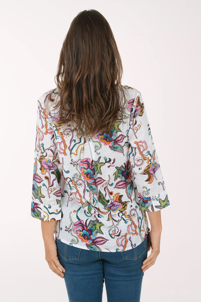 Woman wearing a colorful floral blouse on a white background