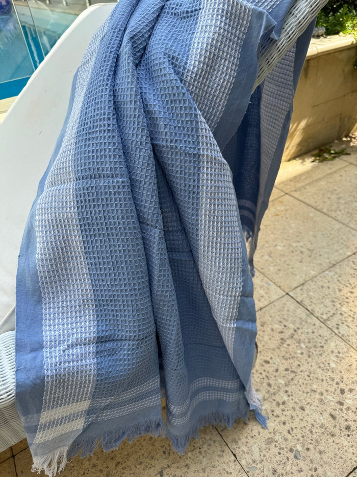 Periwinkle Border Waffle Towel across a lounge chair - ANNIE.G