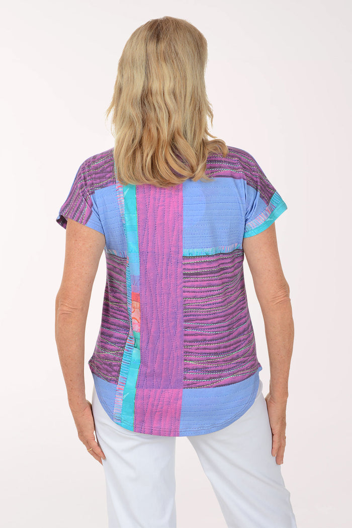 Woman wearing a colorful patterned top on a white background