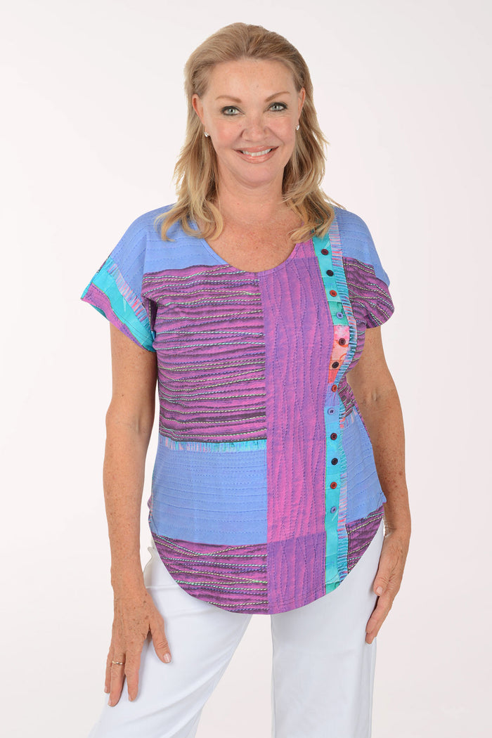Woman wearing a colorful patterned top on a white background