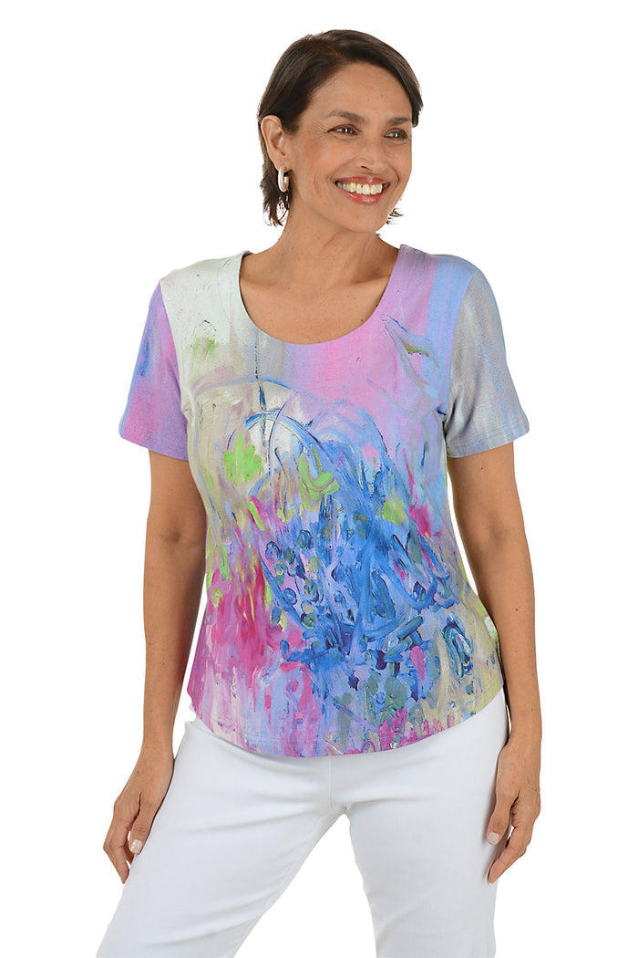 Woman wearing a colorful abstract patterned top on a white background.