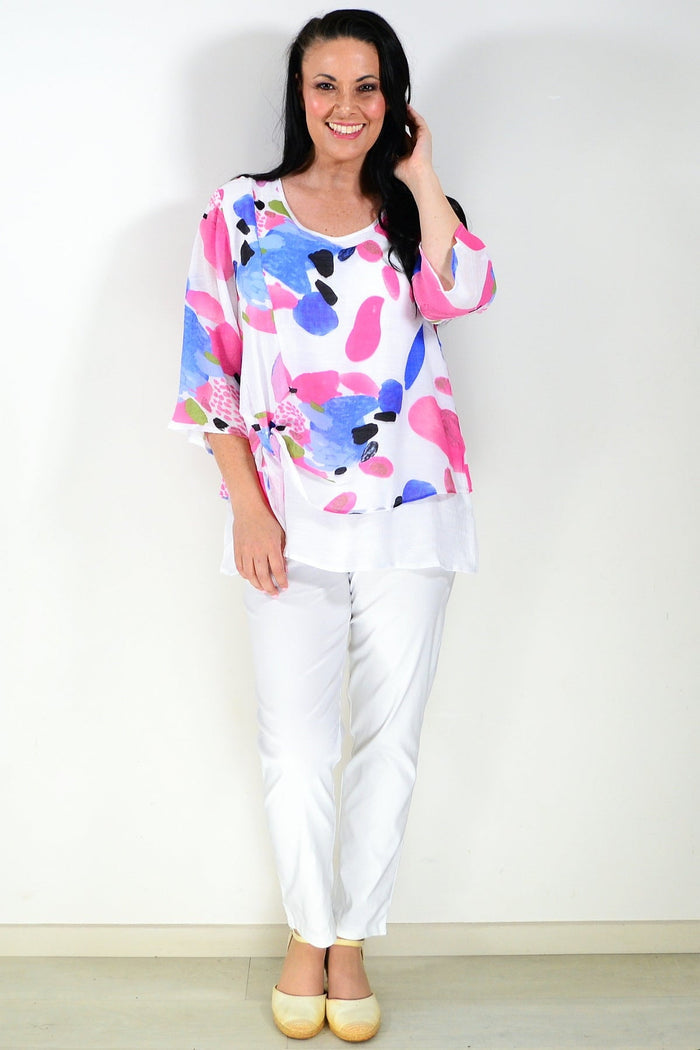 Pink and blue paint splash tunic top from Wishstone, featuring vibrant abstract design and relaxed fit, displayed on a hanger.
